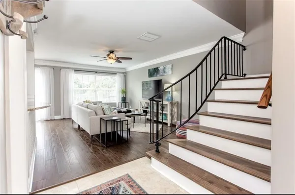 a living room with wooden floor and a dining table