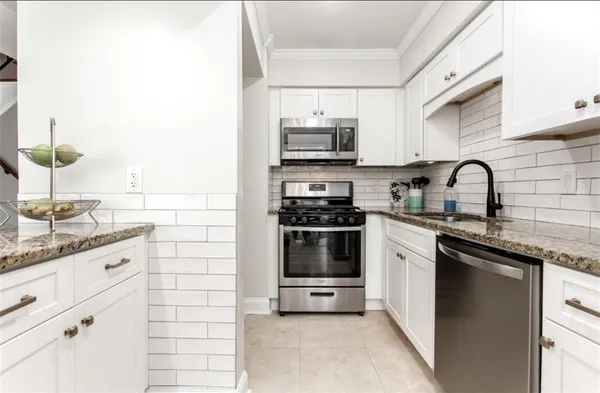 a kitchen with stainless steel appliances a sink cabinets and a stove top oven