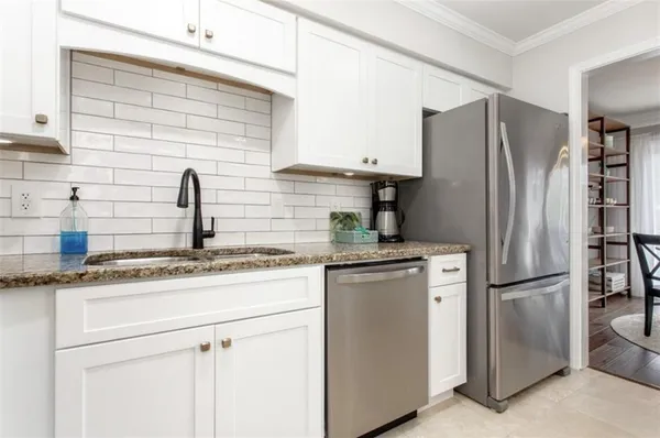 a kitchen with stainless steel appliances granite countertop a refrigerator and a sink