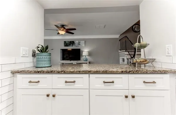 a kitchen with stainless steel appliances granite countertop a sink and a white cabinets