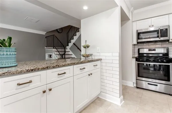 a kitchen with granite countertop a stove and a sink