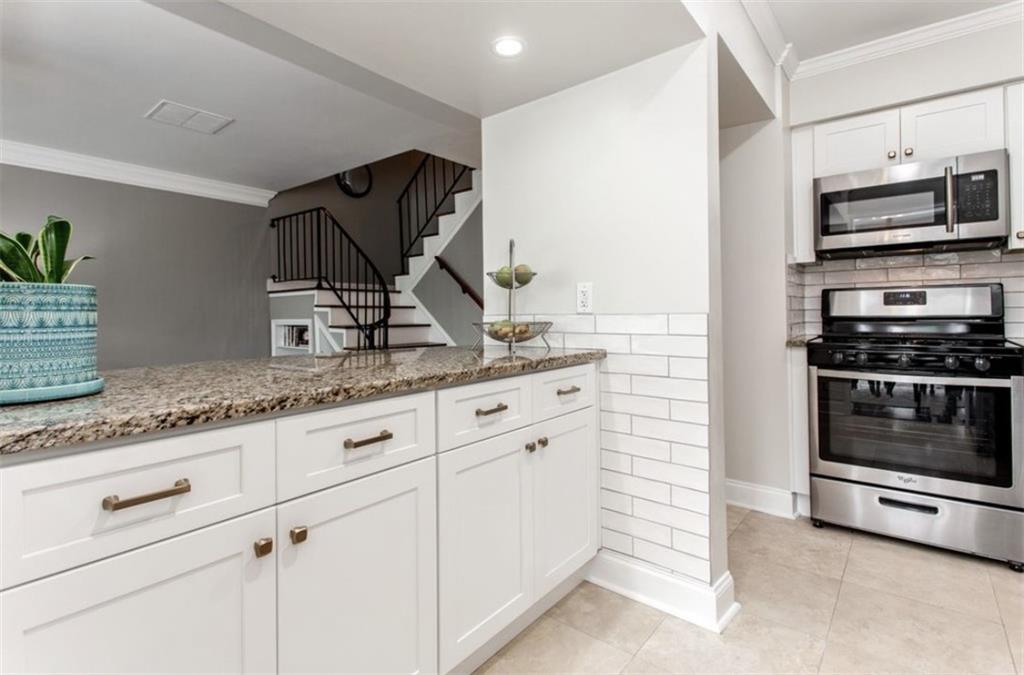 6980 Roswell Road, Unit B6 Atlanta, GA 30328 - Photo 9 of 30 a kitchen with granite countertop a stove and a sink