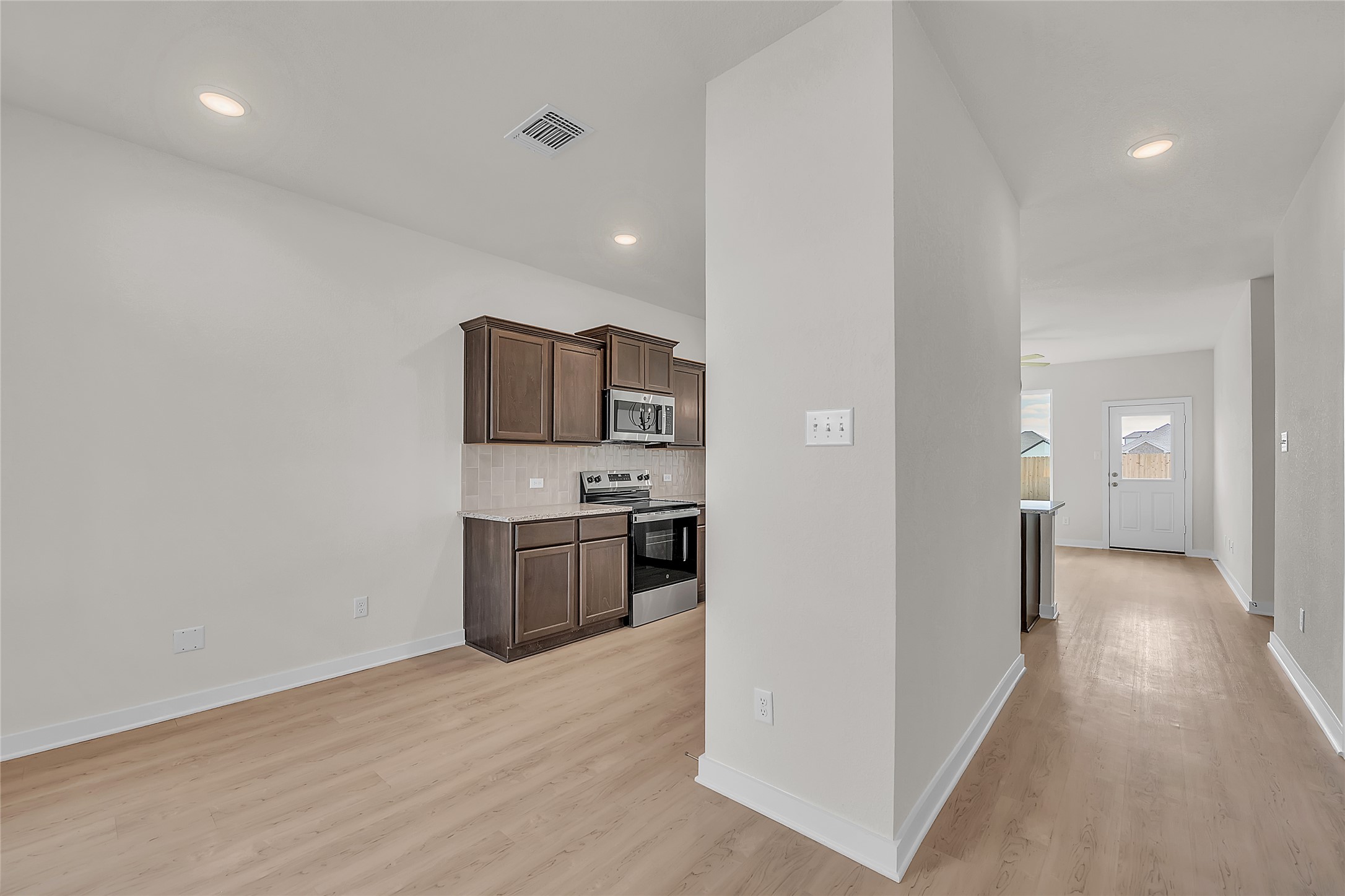 308 Boatright Boulevard Jarrell, TX 76537 - Photo 28 of 31 Kitchen featuring stainless steel appliances, dark brown cabinets, decorative backsplash, recessed lighting, and light wood-style flooring