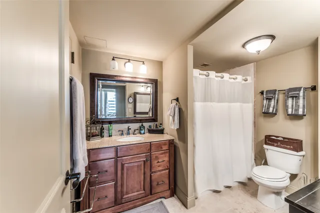 a bathroom with a toilet sink double vanity and mirror