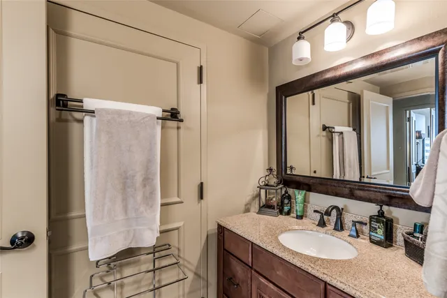 a bathroom with a granite countertop sink a mirror and a shower