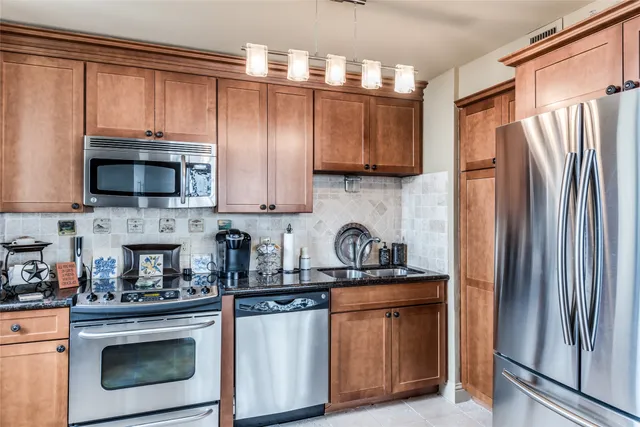 a kitchen with stainless steel appliances granite countertop a refrigerator stove and sink
