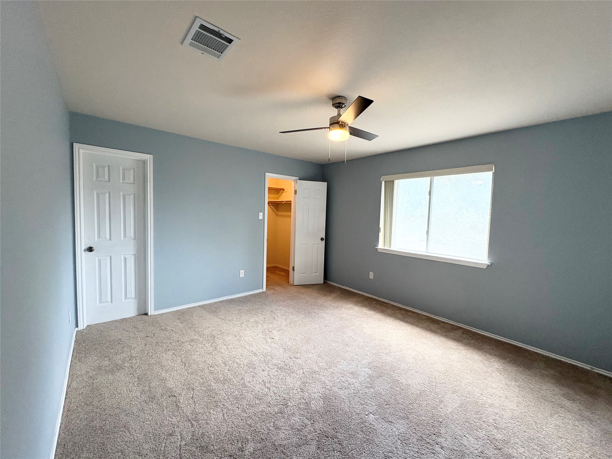8103 Ephraim Road Austin, TX 78717 - Photo 19 of 35 A comfortable bedroom features plush carpeting, a wide window, and a ceiling fan for year-round comfort.