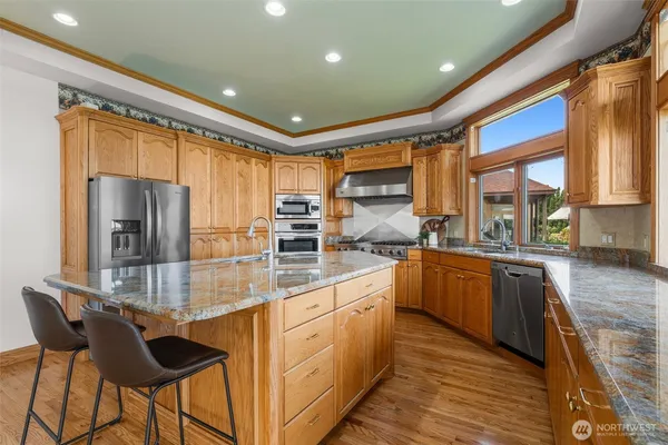 a kitchen with stainless steel appliances granite countertop a stove and a sink