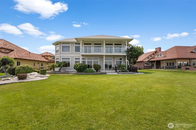 a view of a big house with a big yard and large trees