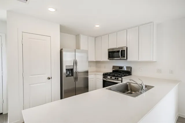 a kitchen with a refrigerator a microwave a stove and cabinets