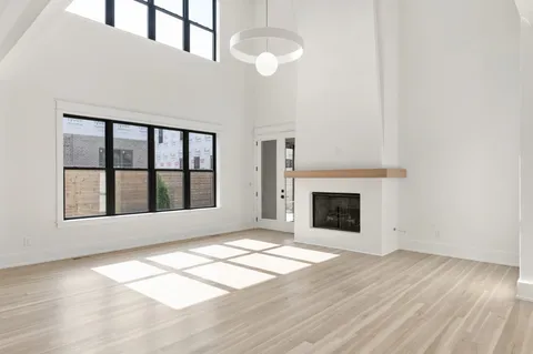 a view of an empty room with glass door and windows