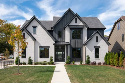 a front view of yellow house with a yard