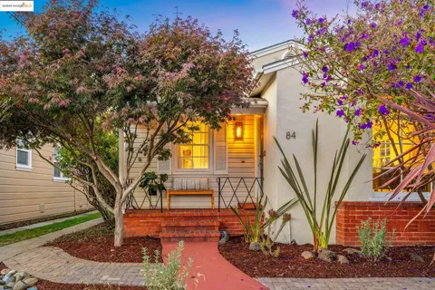 a front view of a house with a tree