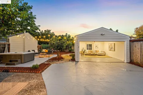 a living room with patio furniture and a potted plant
