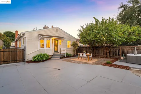 a view of a patio with couches table and chairs with wooden fence and plants