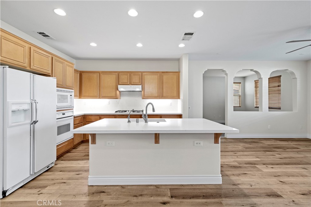 28355 Stansfield Lane Saugus, CA 91350 - Photo 12 of 52 a kitchen with kitchen island a sink a stove a refrigerator and white cabinets