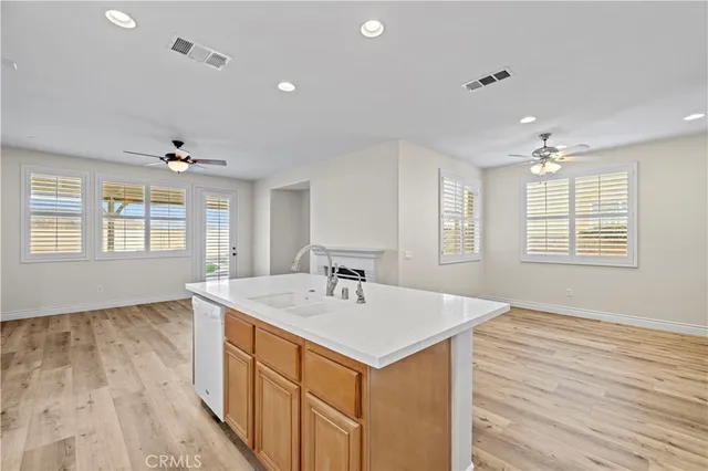 a view of a kitchen and a sink cabinet a fireplace wooden floor and cabinet