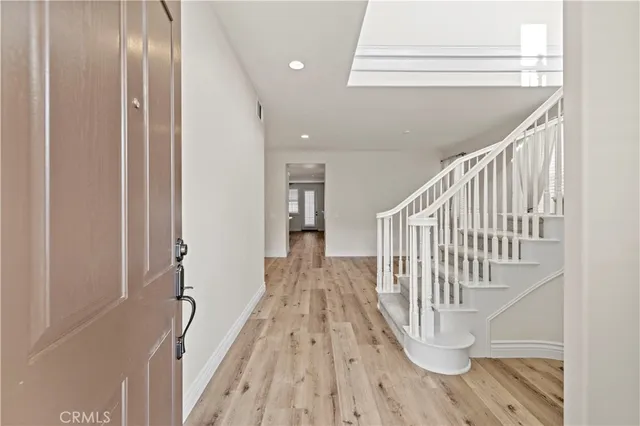 a view of a hallway with wooden floor and staircase