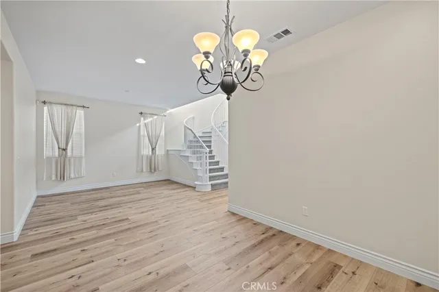 a view of a room with wooden floor and chandelier