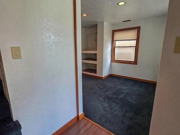 an empty room with a hallway and closet