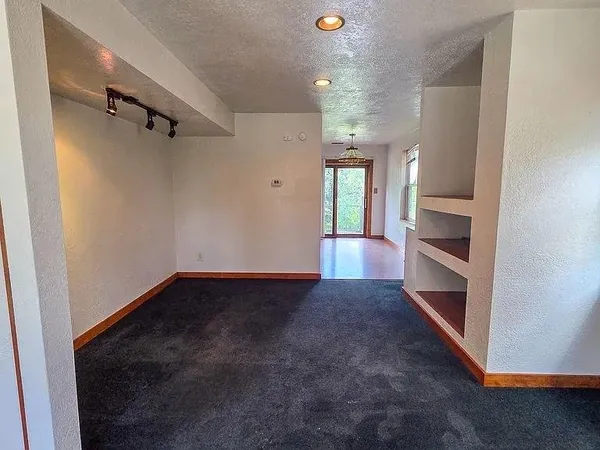 a view of an empty room with a fireplace and a window