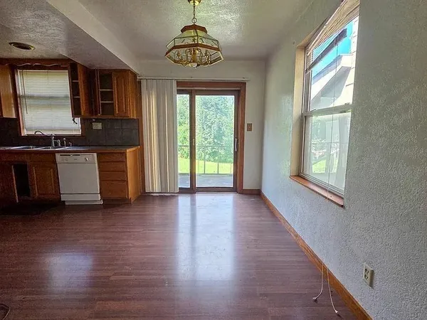 a view of a kitchen with a stove wooden cabinet and a refrigerator