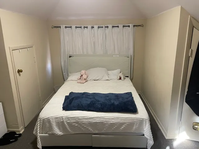 a bedroom with a bed and a window