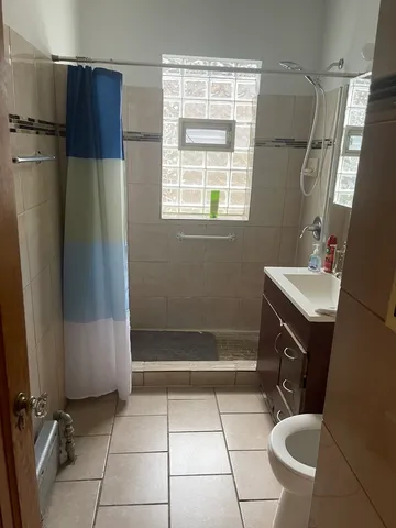 a bathroom with a sink a toilet a mirror and shower