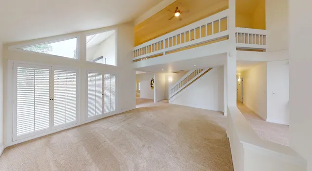 a view of an empty room with a fireplace and a window