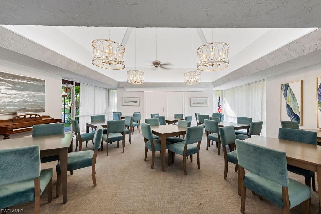 180 Turtle Lake Court, Unit 106 Naples, FL 34105 - Photo 14 of 17 a view of a dining room with furniture and chandelier
