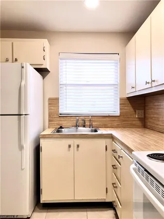 a kitchen with granite countertop a sink and a refrigerator