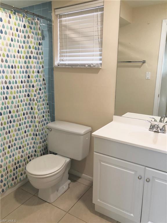 180 Turtle Lake Court, Unit 106 Naples, FL 34105 - Photo 7 of 17 a white toilet sitting next to a bathroom sink