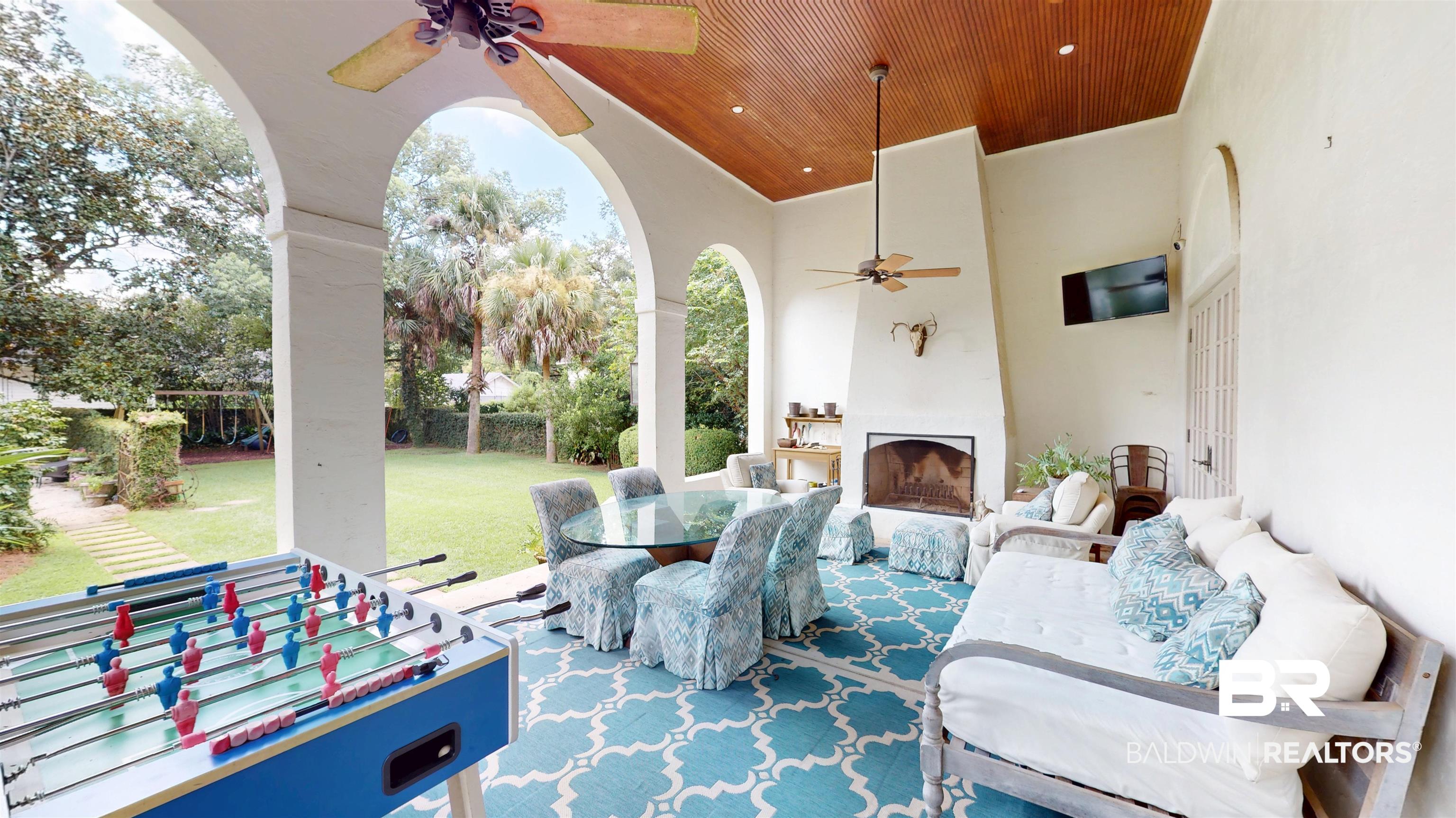 211 Lanier Avenue Mobile, AL 36607 - Photo 58 of 73 View of patio / terrace with a ceiling fan, an outdoor living space with a fireplace, and outdoor dining space