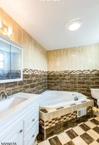 a bathroom with a granite countertop bathtub and a shower