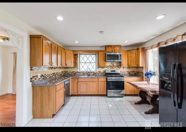 a kitchen with stainless steel appliances granite countertop a stove sink and cabinets
