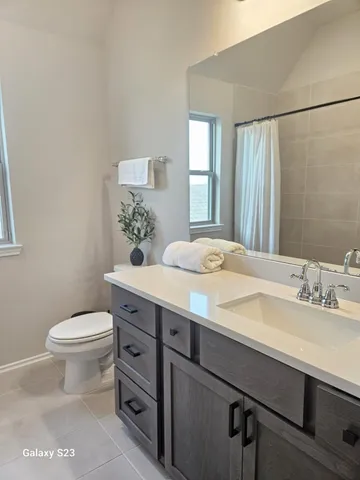 a bathroom with a granite countertop sink a toilet and a mirror