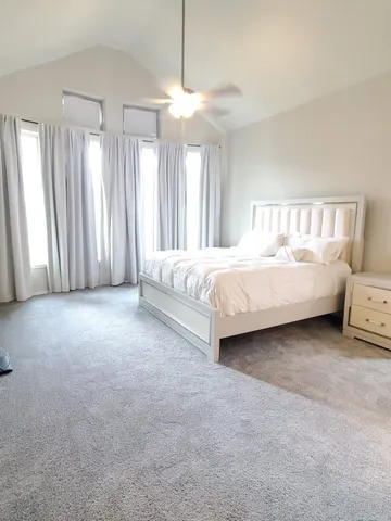 a spacious bedroom with a bed and a large window