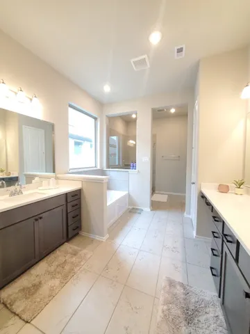 a large bathroom with a large tub sink shower and mirror