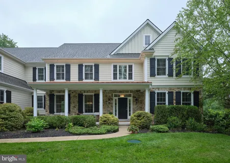 a front view of a house with a yard and trees