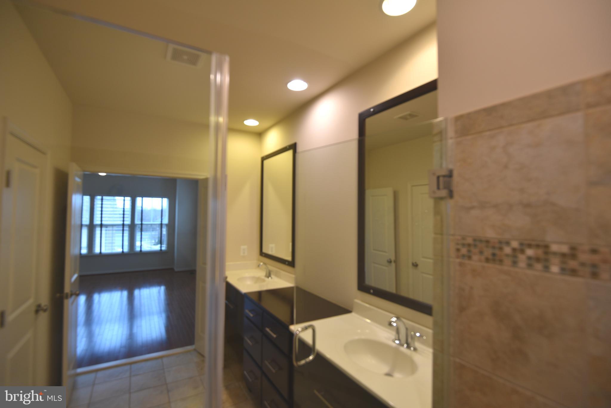 20425 Codman Drive Ashburn, VA 20147 - Photo 21 of 36 a bathroom with a sink mirror and shower