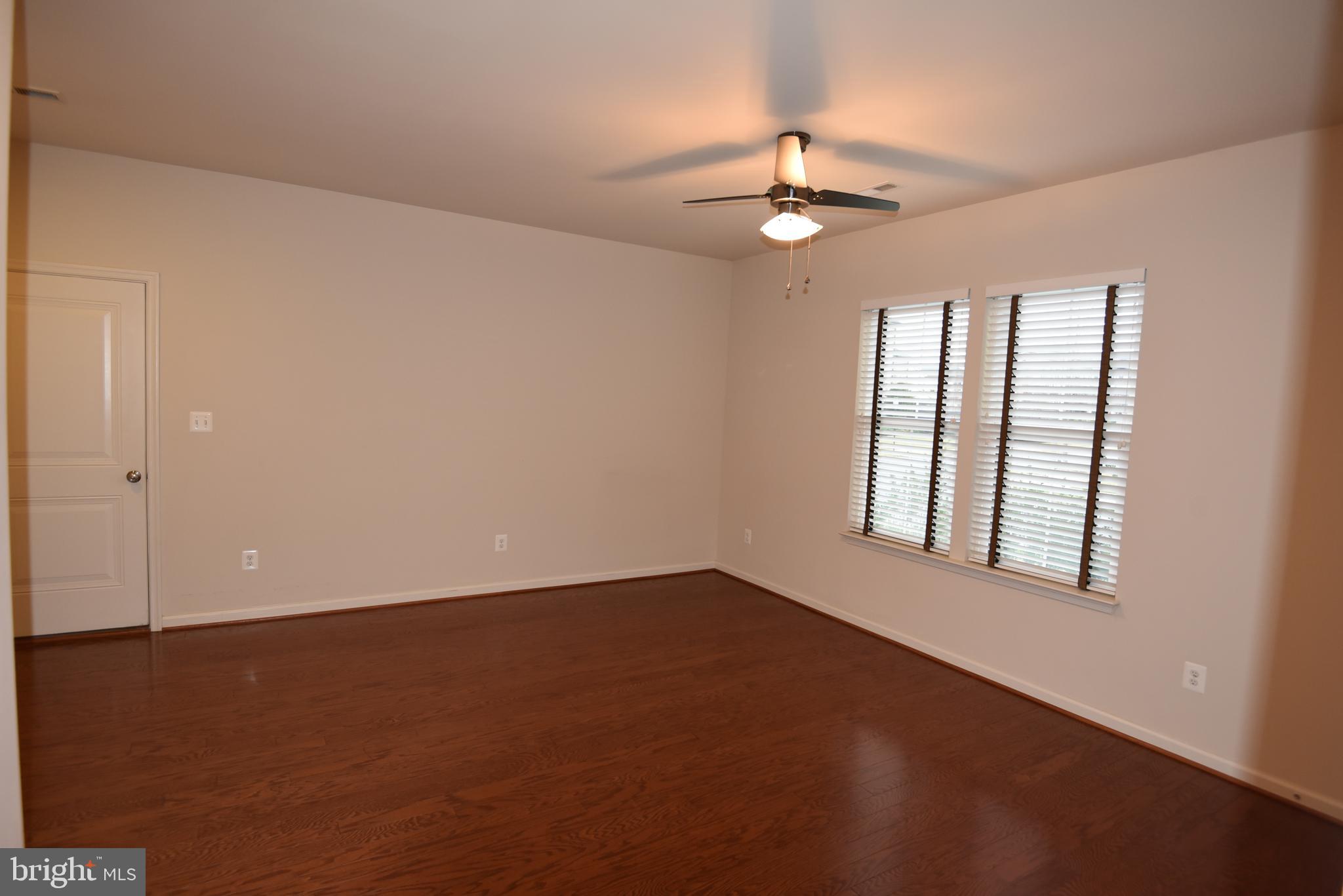 20425 Codman Drive Ashburn, VA 20147 - Photo 27 of 36 an empty room with chandelier fan and windows