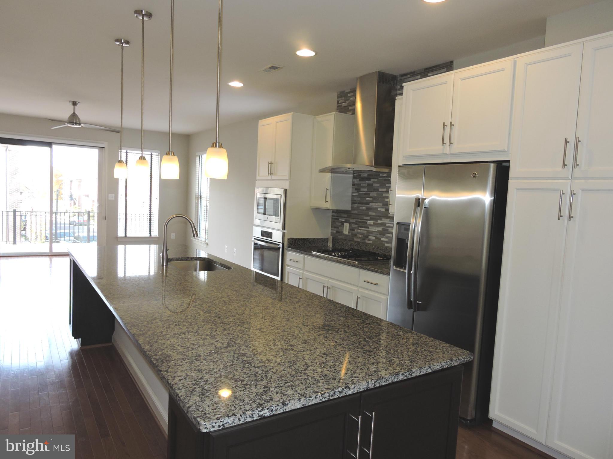 20425 Codman Drive Ashburn, VA 20147 - Photo 4 of 36 a kitchen with stainless steel appliances granite countertop a sink a refrigerator and a sink