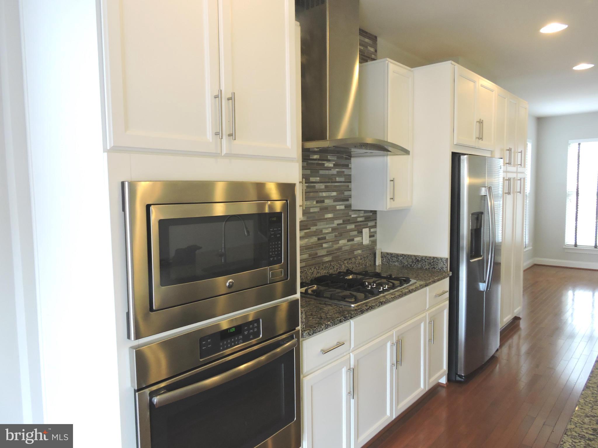 20425 Codman Drive Ashburn, VA 20147 - Photo 6 of 36 a kitchen with granite countertop white cabinets and stainless steel appliances