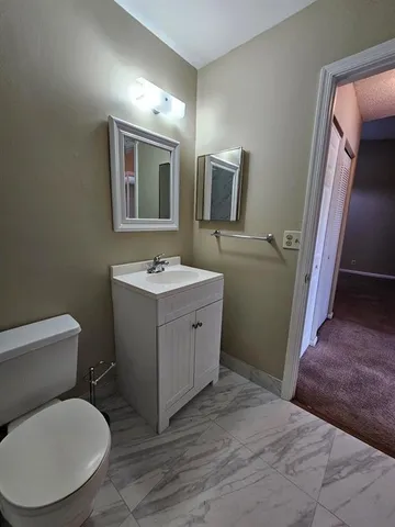a bathroom with a toilet sink and mirror