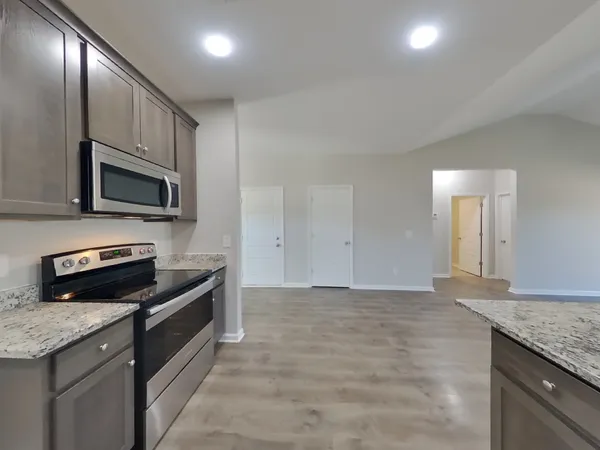 a kitchen with granite countertop stainless steel appliances and wooden cabinets