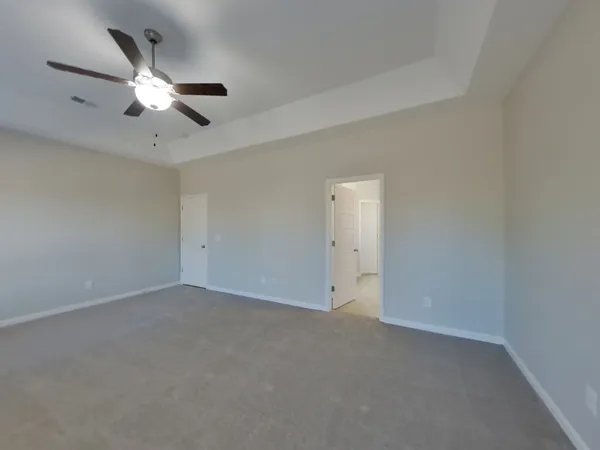 an empty room with a ceiling fan and a window
