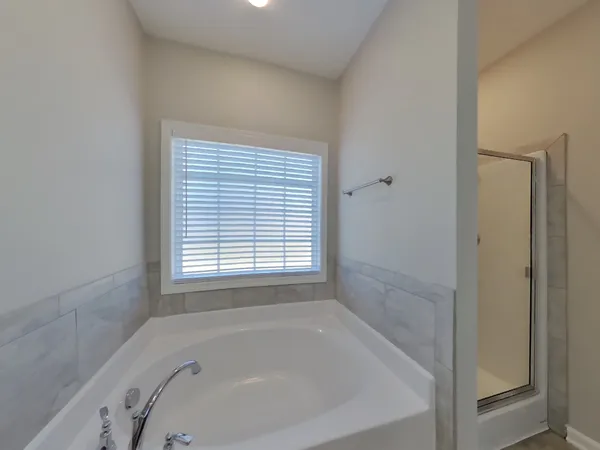 a white bath tub sitting in a bathroom next to a window