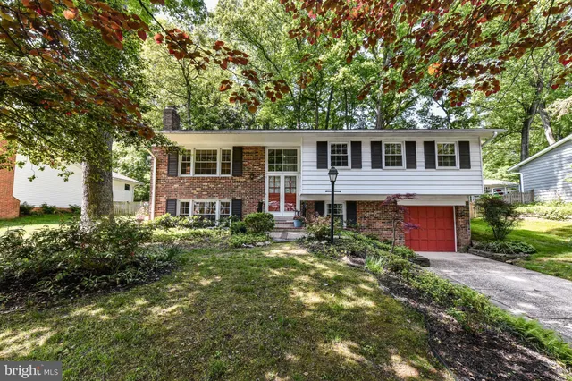 a front view of a house with yard and green space