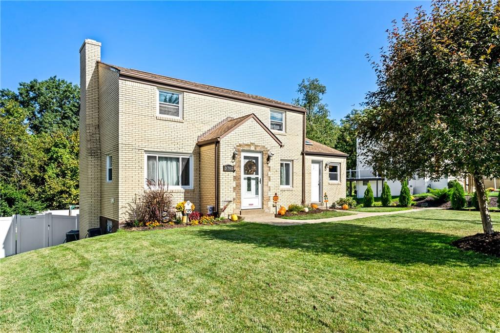 a front view of a house with a yard and trees
