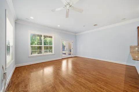a view of an empty room with window and wooden floor
